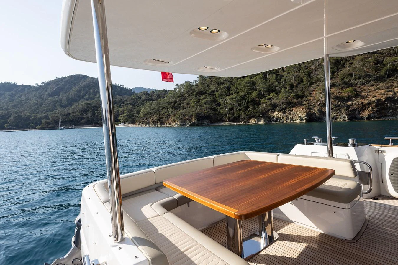 The aft deck features a stylish dining area with a wooden table and comfortable seating. aboard AZ MAGELLANO 66 Yacht for Sale