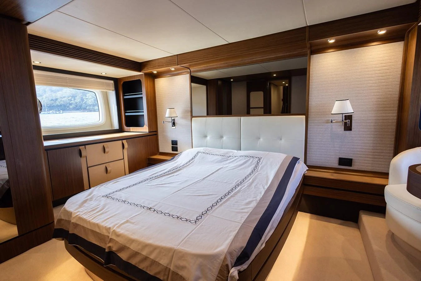 The master stateroom features a spacious bed with elegant wood paneling and ample natural light. aboard AZ MAGELLANO 66 Yacht for Sale