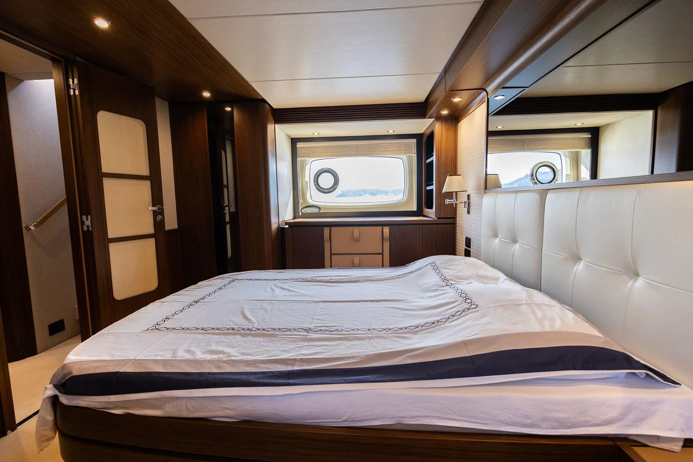 The stateroom features a luxurious bed with elegant linens and ample natural light from the large windows. aboard AZ MAGELLANO 66 Yacht for Sale