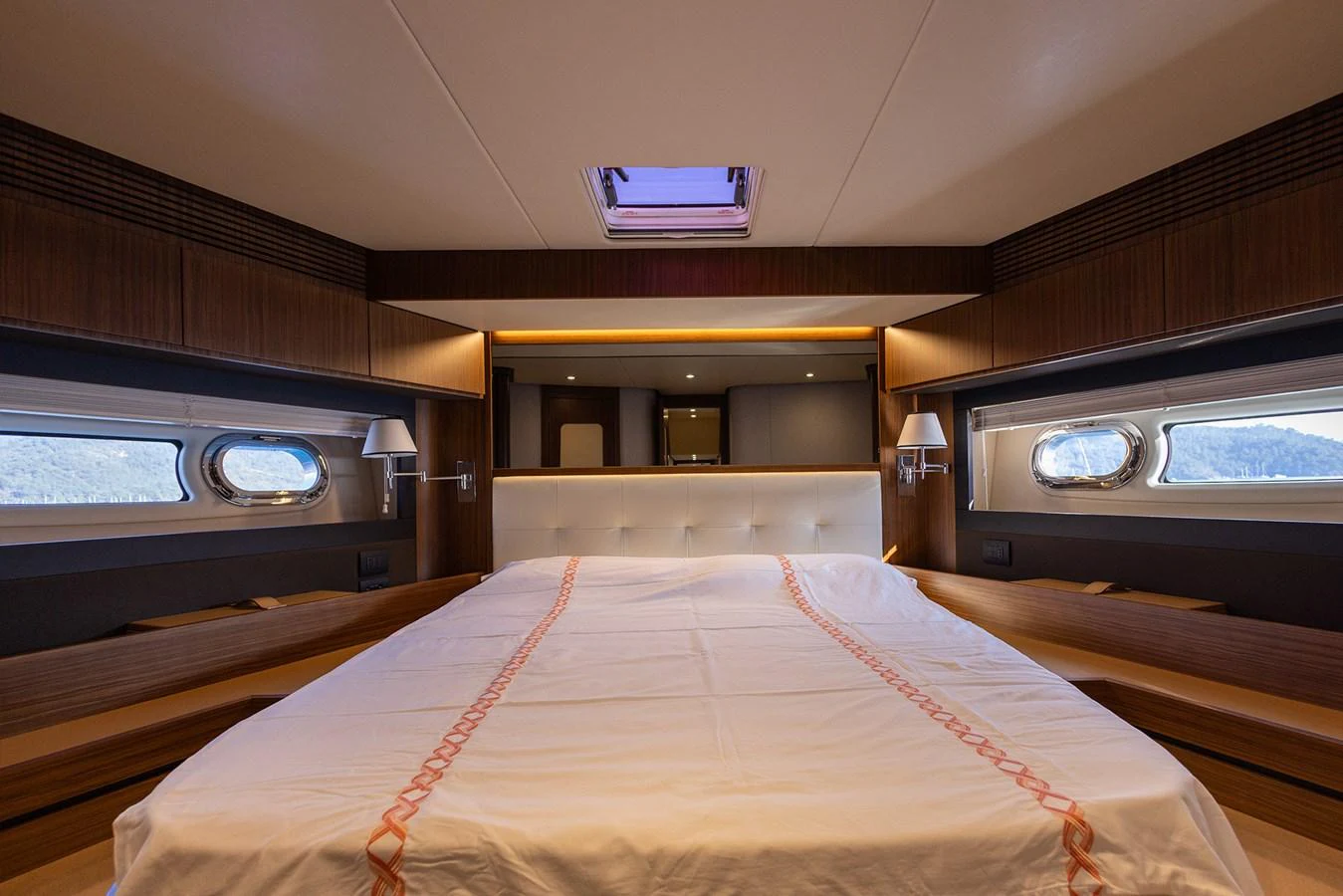 The stateroom features a spacious bed with elegant wood finishes and ample natural light from side windows. aboard AZ MAGELLANO 66 Yacht for Sale