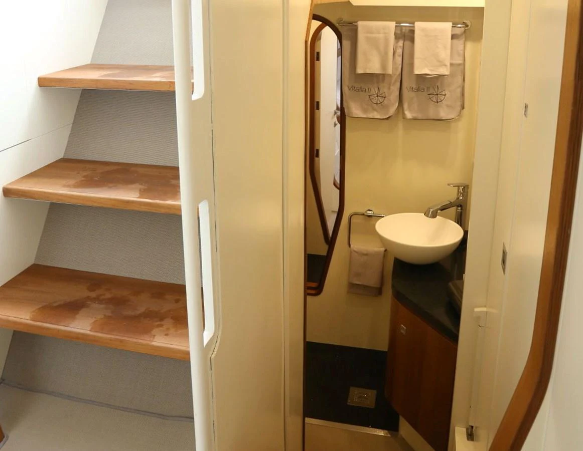 A compact and well-appointed bathroom with wooden accents and modern fixtures. aboard VITALIA II Yacht for Sale