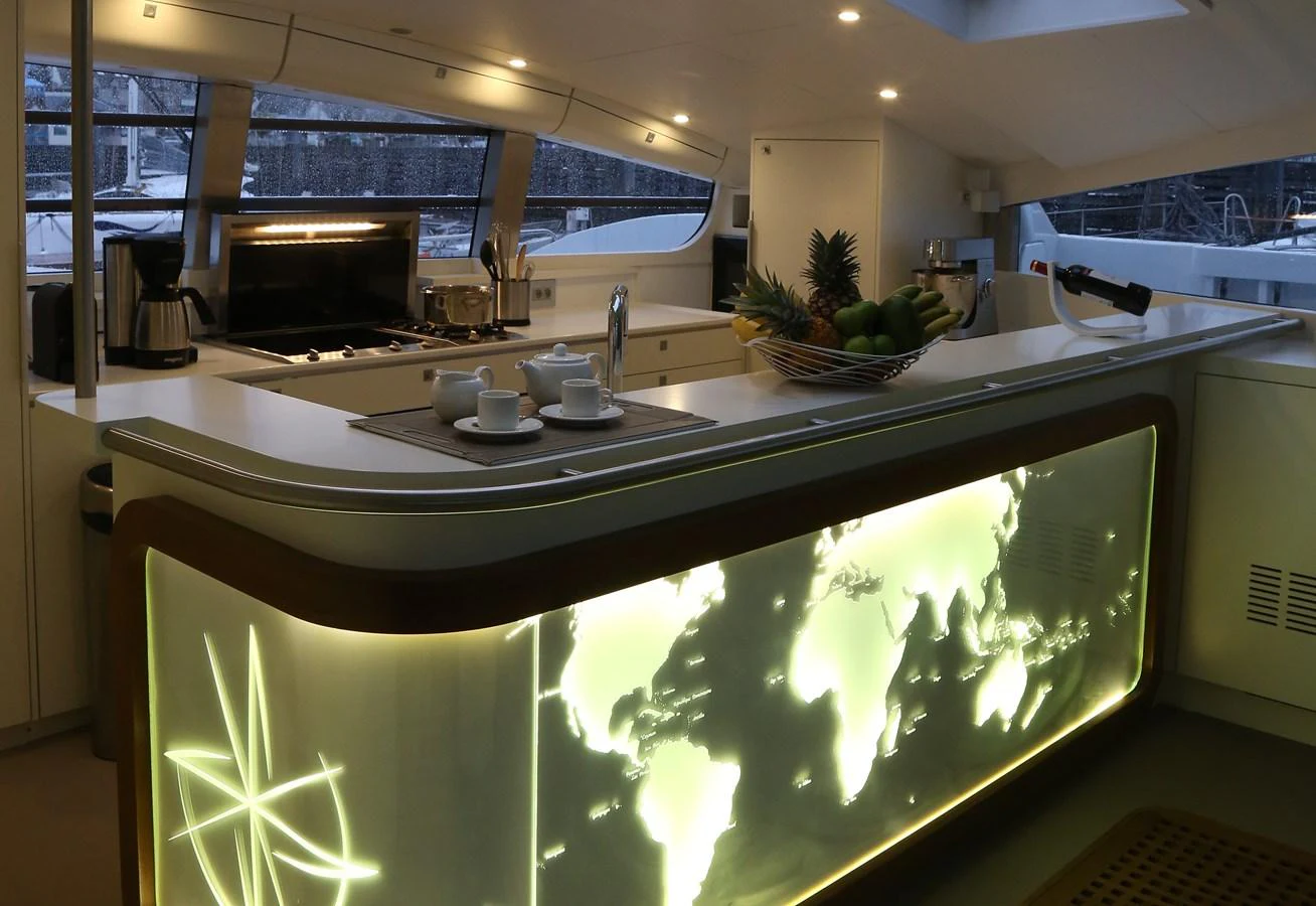 The yacht's galley features a sleek, modern design with a backlit world map and ample counter space. aboard VITALIA II Yacht for Sale