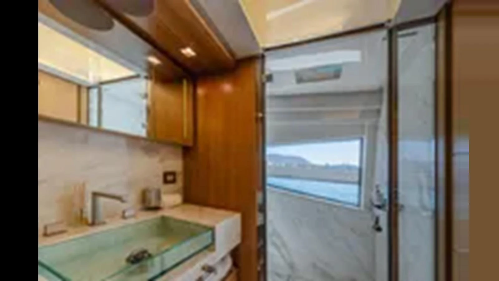 The yacht's interior features a modern bathroom with a glass sink and a view of the water through a window. aboard 2012 FERRETTI YACHTS CUSTOM LINE 100 Yacht for Sale