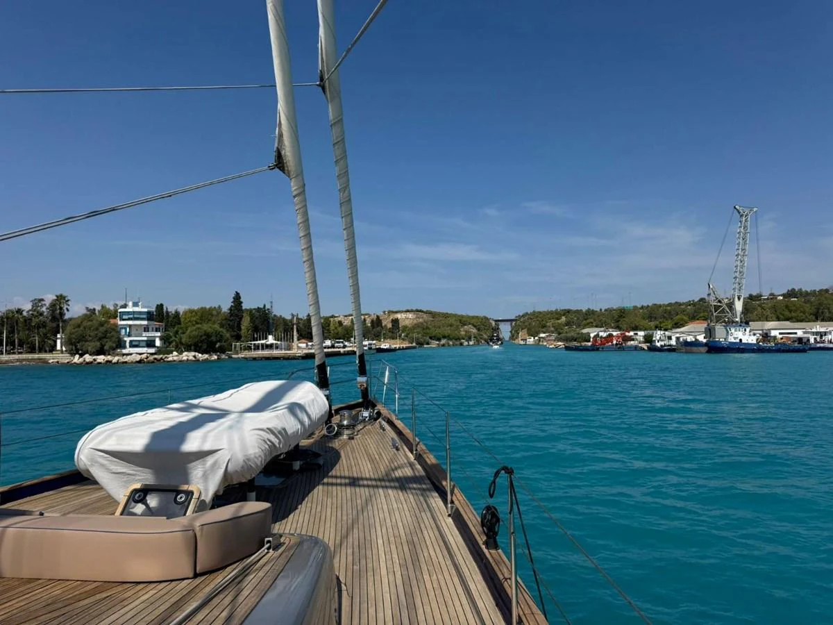 A serene view from the deck of a yacht cruising through calm waters with a clear blue sky. aboard PATRIOT Yacht for Sale