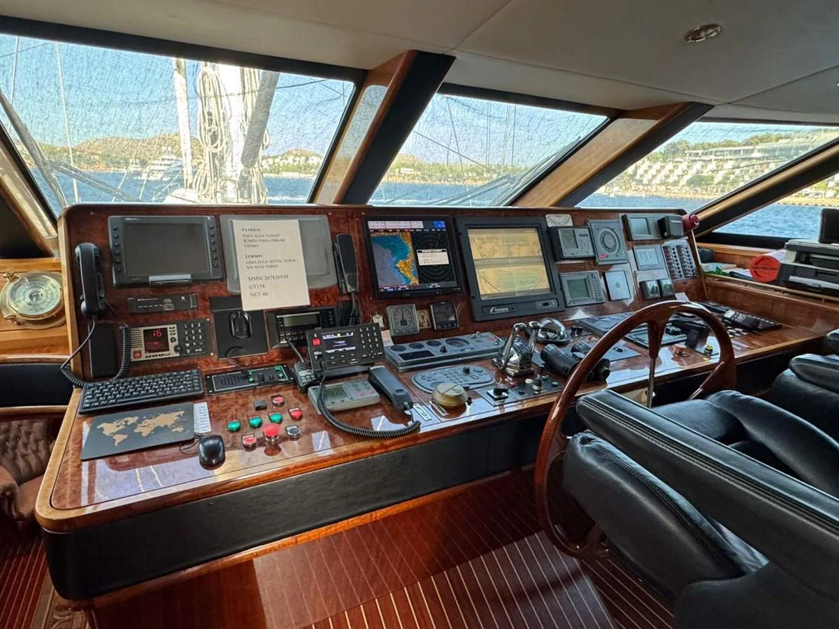 The helm station features an array of advanced navigation and control equipment, set against a backdrop of large windows offering panoramic views. aboard PATRIOT Yacht for Sale