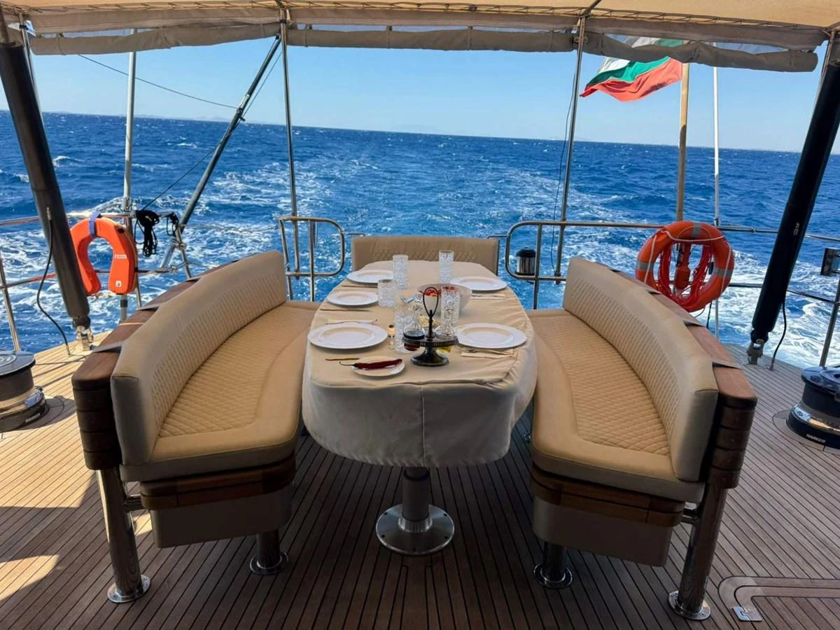 The aft deck features a cozy dining area with a stunning ocean view. aboard PATRIOT Yacht for Sale