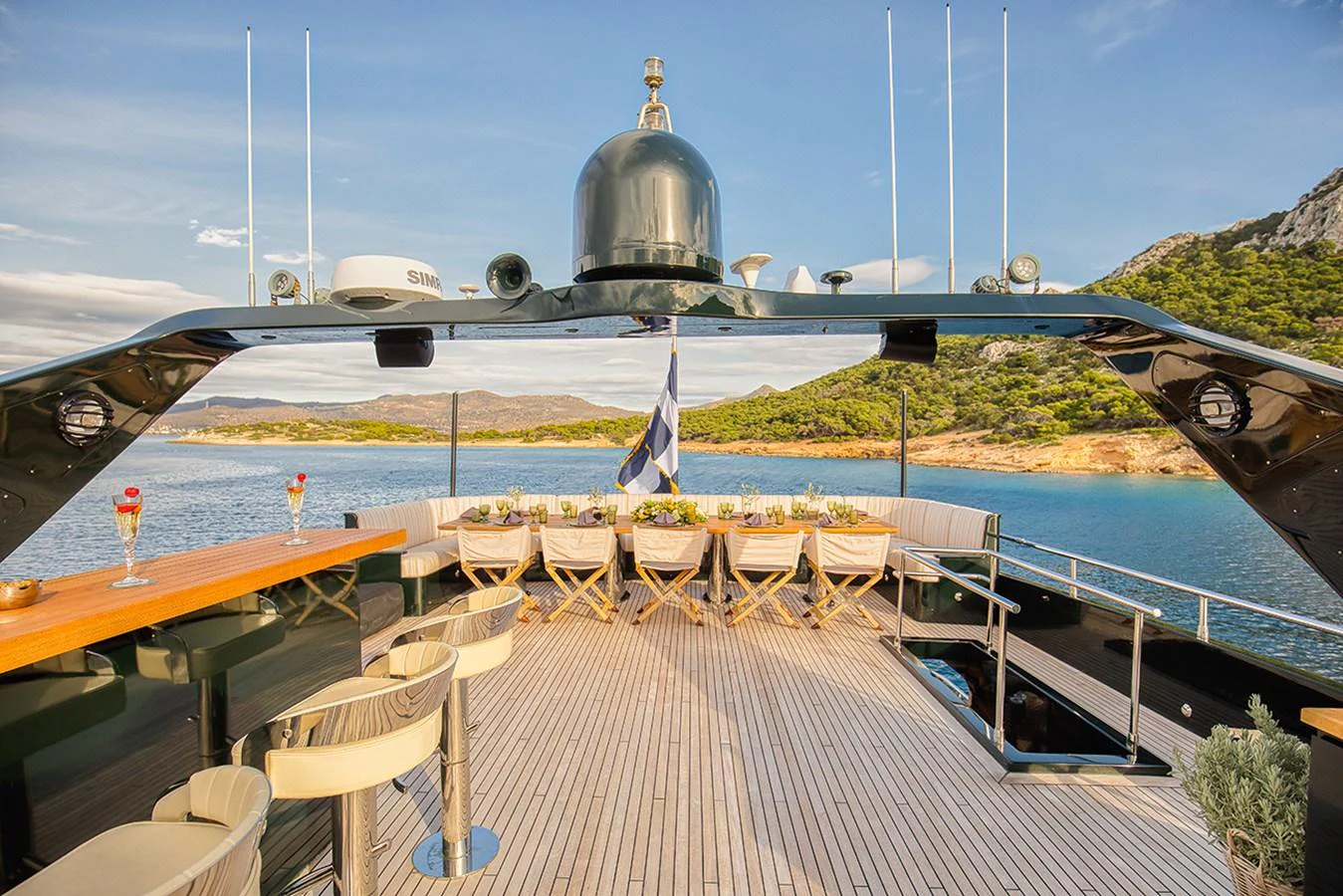 The yacht's aft deck features an elegant outdoor dining area with a scenic view. aboard CAN'T REMEMBER Yacht for Sale