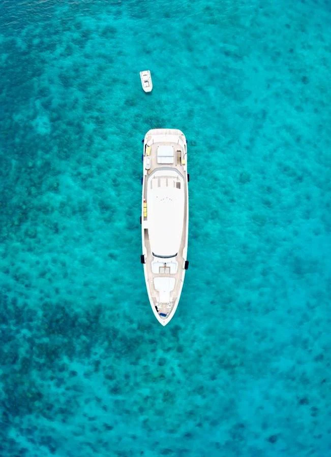 Aerial view of a luxurious yacht anchored in crystal-clear turquoise waters. aboard LUZ DE MAR Yacht for Sale