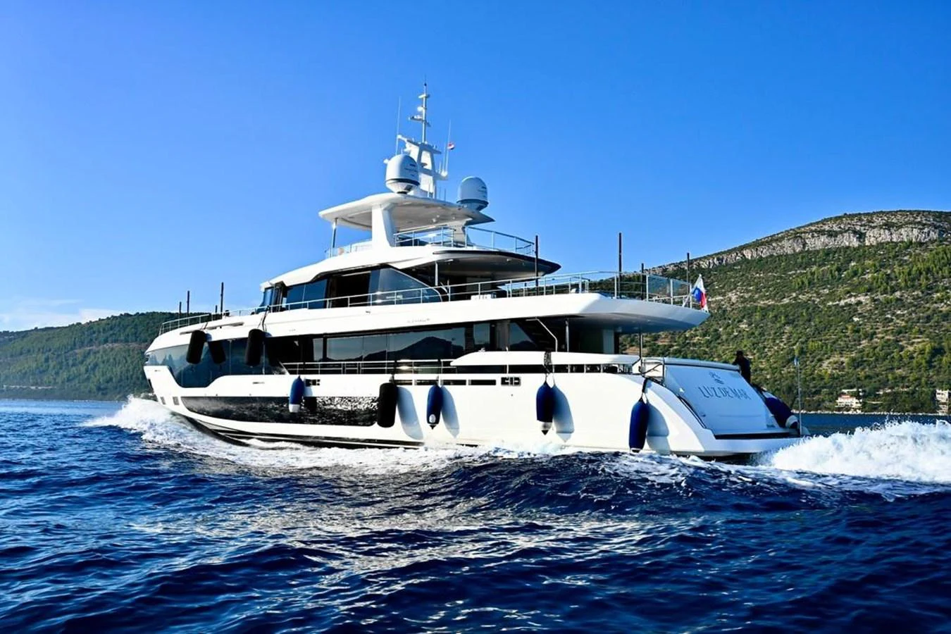 A luxurious yacht cruising on the open water with a scenic backdrop. aboard LUZ DE MAR Yacht for Sale