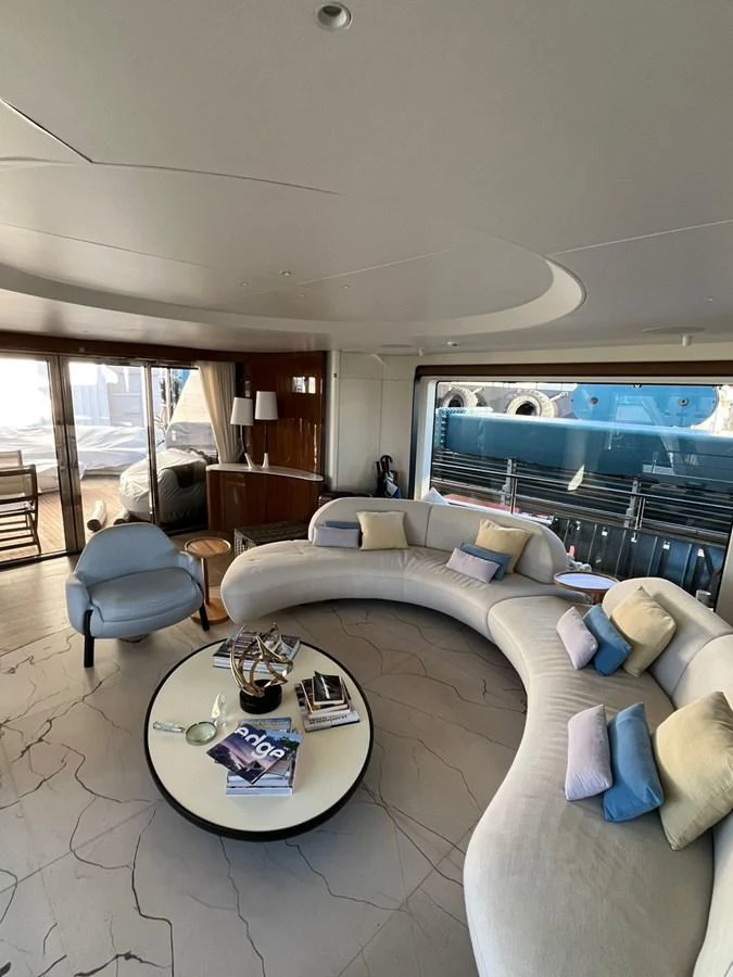 The yacht's salon features a stylish curved sofa and modern decor, offering a comfortable and elegant space for relaxation. aboard LUZ DE MAR Yacht for Sale