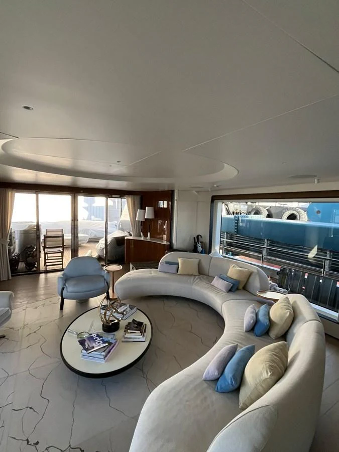 The salon features a spacious and elegantly designed seating area with large windows offering a view of the exterior. aboard LUZ DE MAR Yacht for Sale