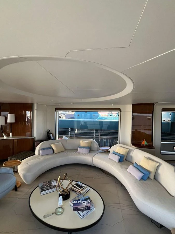 The salon features a modern, curved sofa with plush cushions and a stylish coffee table, creating a cozy and elegant atmosphere. aboard LUZ DE MAR Yacht for Sale