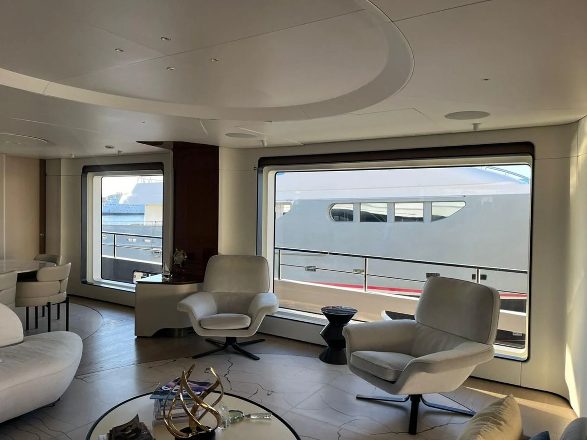 The yacht's interior features a modern and spacious lounge area with large windows providing ample natural light. aboard LUZ DE MAR Yacht for Sale