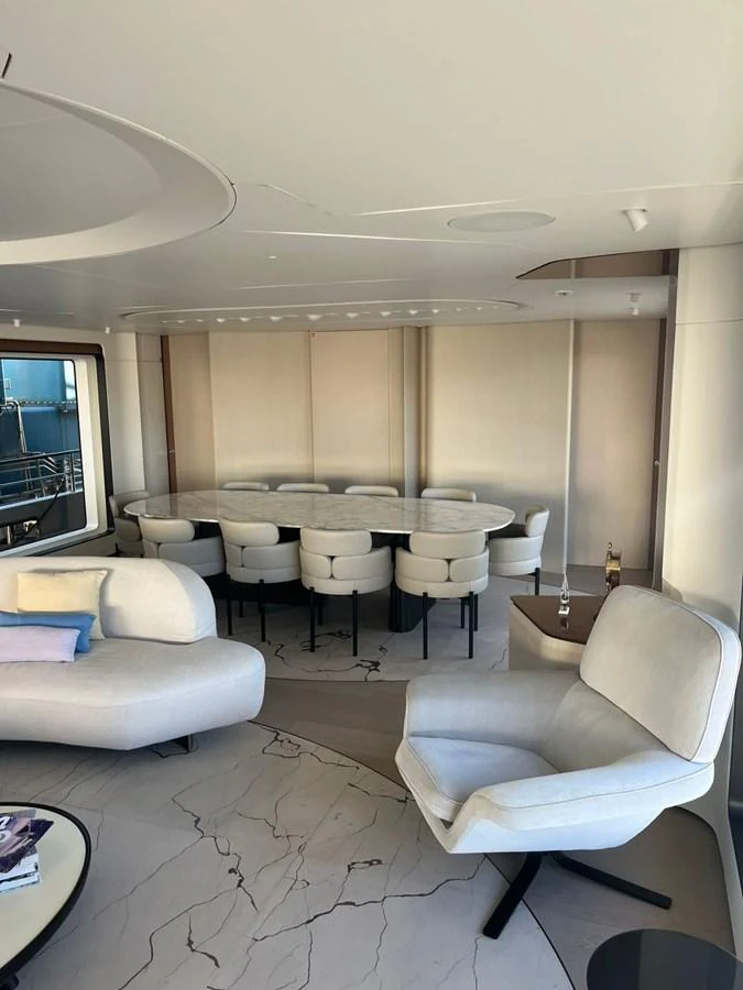 The yacht's salon features a modern and elegant seating area with a large dining table and plush chairs. aboard LUZ DE MAR Yacht for Sale