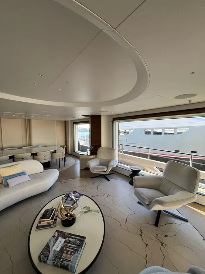 The salon features modern furnishings with large windows offering a view of the exterior. aboard LUZ DE MAR Yacht for Sale