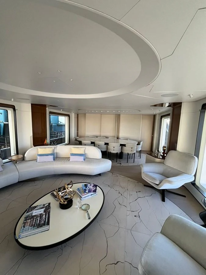 The yacht's salon features elegant seating and a modern dining area with panoramic windows. aboard LUZ DE MAR Yacht for Sale