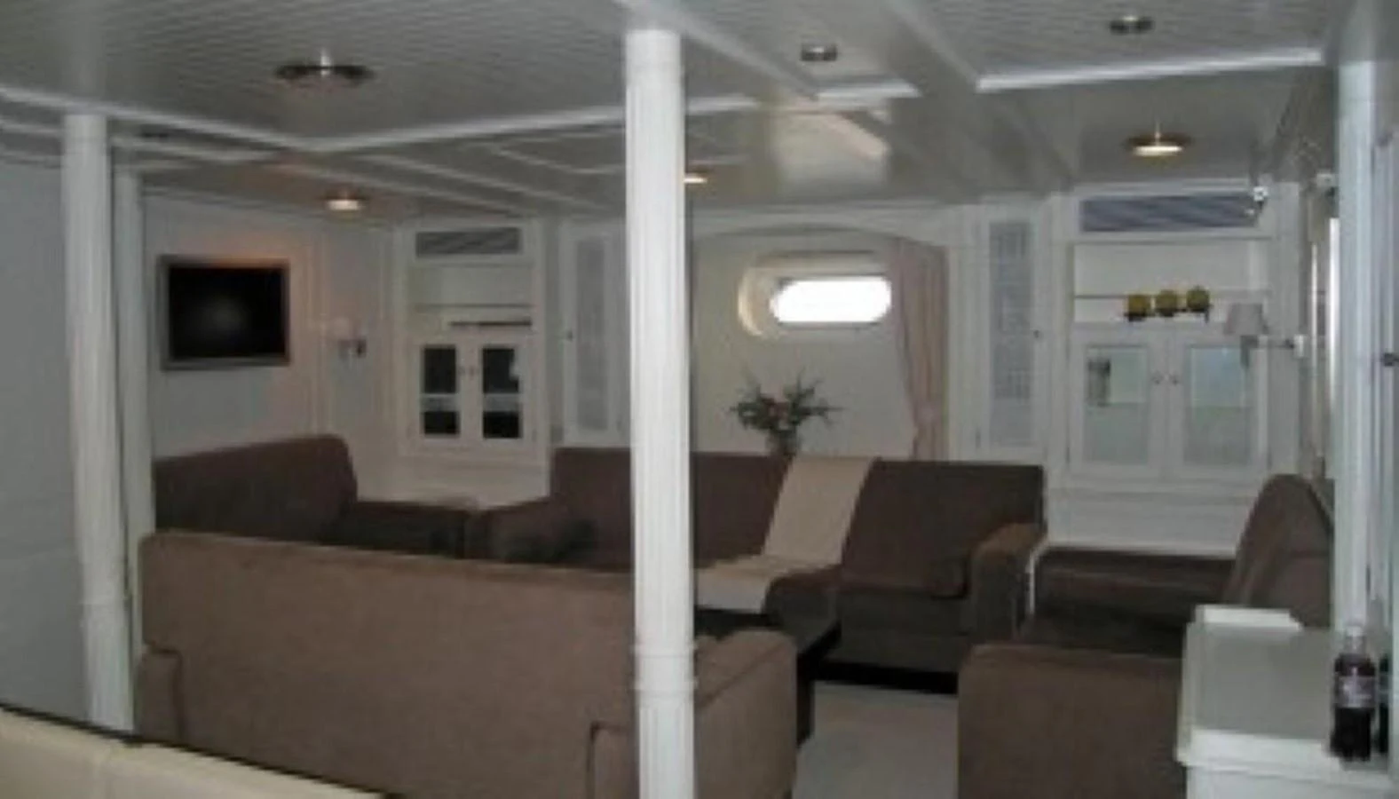 The salon features comfortable seating with a neutral color palette and ample natural light. aboard MARI-CHA III Yacht for Sale