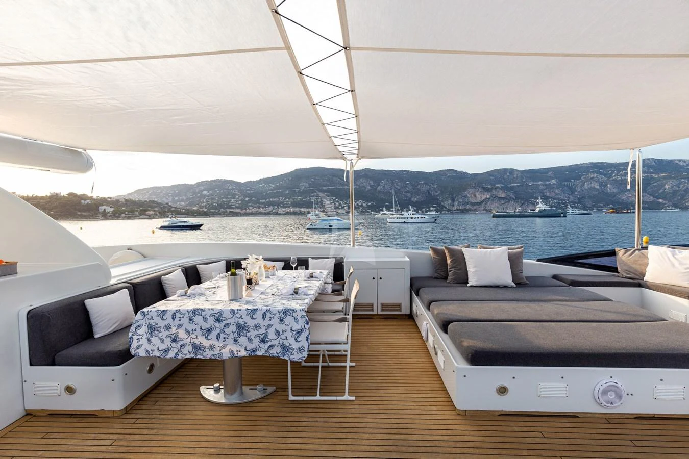 The aft deck features a spacious lounging area with a dining table and comfortable seating, perfect for enjoying meals with a view of the sea. aboard TALILA Yacht for Sale