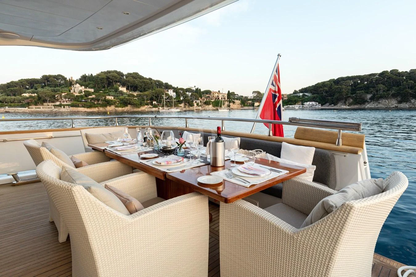 The aft deck features an elegant dining area with a stunning view of the coastline. aboard TALILA Yacht for Sale