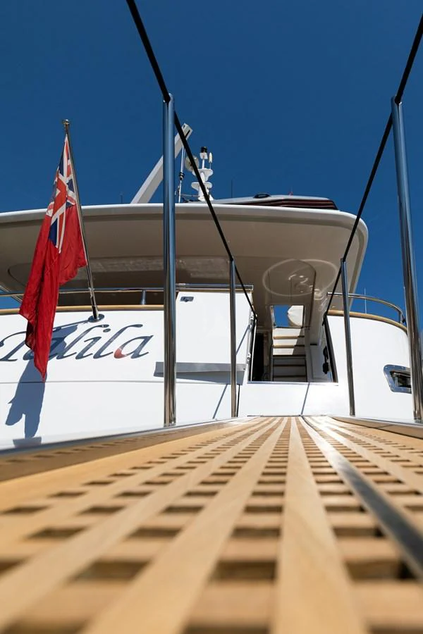 A view from the gangway leading up to the yacht's aft deck, showcasing the yacht's name and flag. aboard TALILA Yacht for Sale