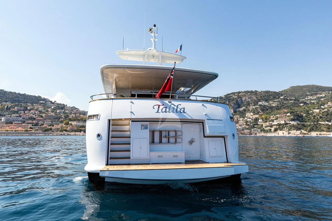 The yacht's aft deck is showcased with a view of the surrounding coastal landscape. aboard TALILA Yacht for Sale