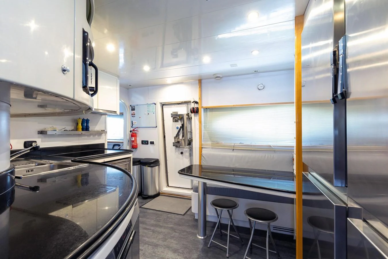 The yacht's galley features modern appliances, a sleek dining area, and ample storage space. aboard TALILA Yacht for Sale