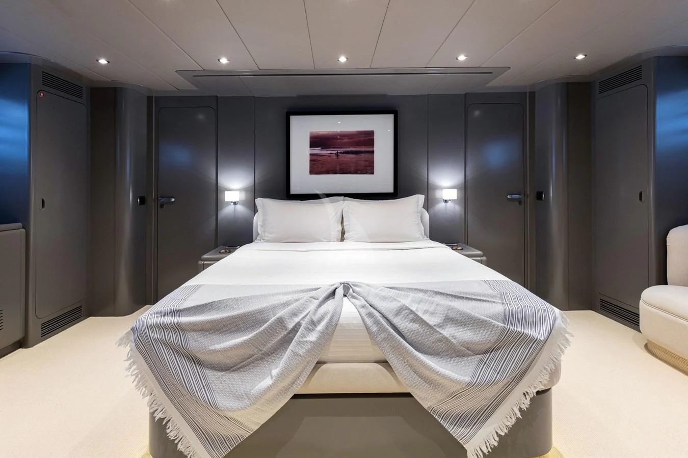 The master stateroom features a luxurious bed with elegant bedding and modern lighting. aboard TALILA Yacht for Sale