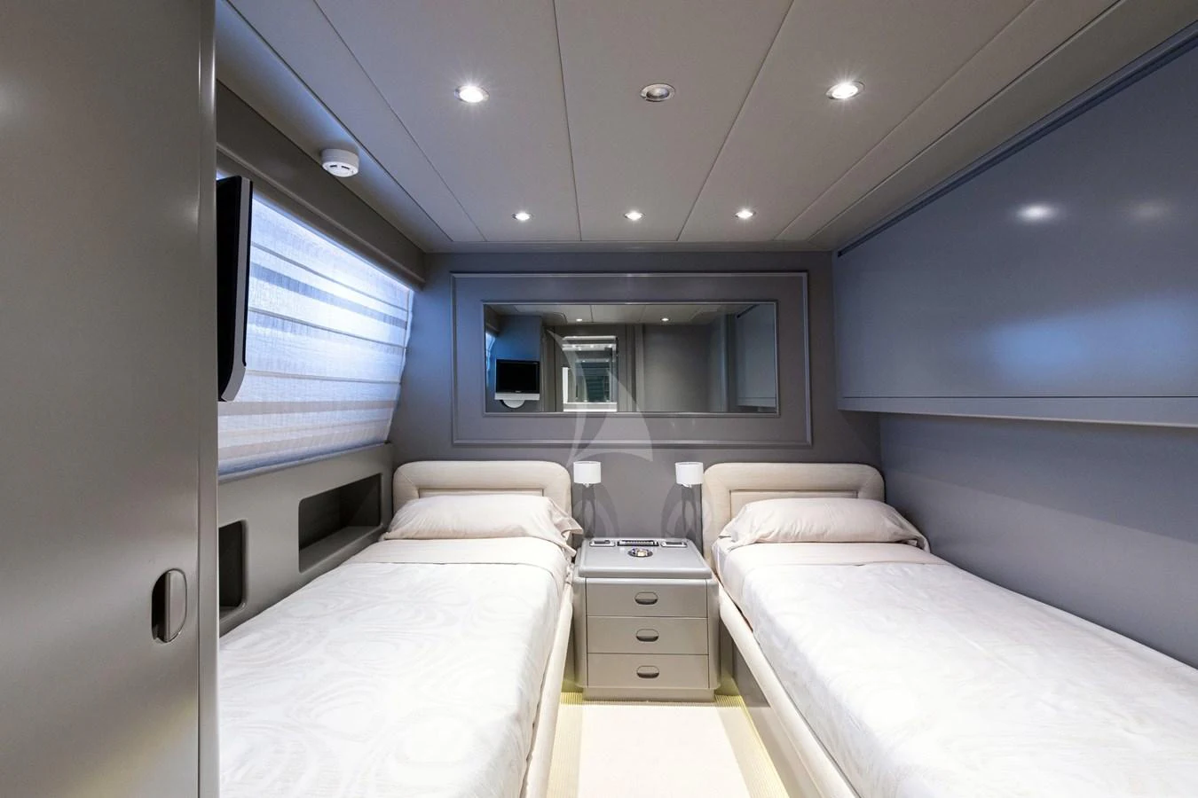 The twin stateroom features two single beds with a sleek, modern design and ample lighting. aboard TALILA Yacht for Sale
