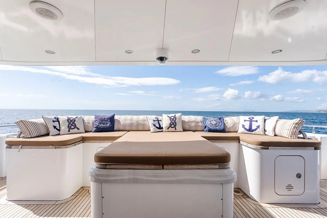 The aft deck features a spacious seating area with nautical-themed cushions, perfect for relaxation and enjoying the sea view. aboard BANDIDO Yacht for Sale