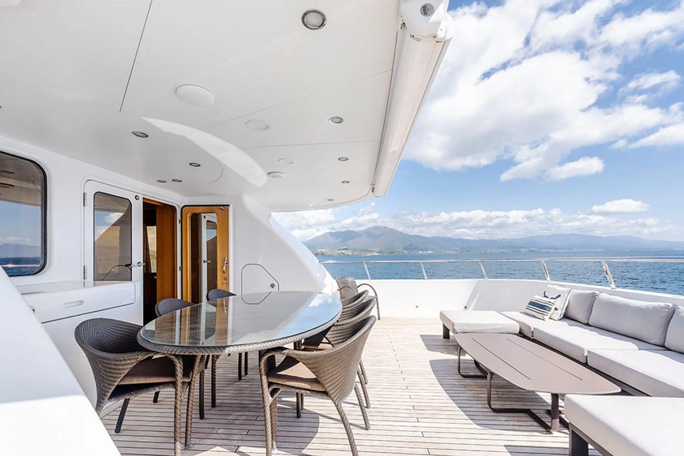 The aft deck features a spacious outdoor dining area with a stunning ocean view. aboard BANDIDO Yacht for Sale