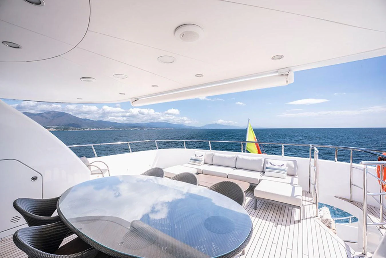 The aft deck features a spacious seating area with a large glass table, perfect for outdoor dining and relaxation. aboard BANDIDO Yacht for Sale
