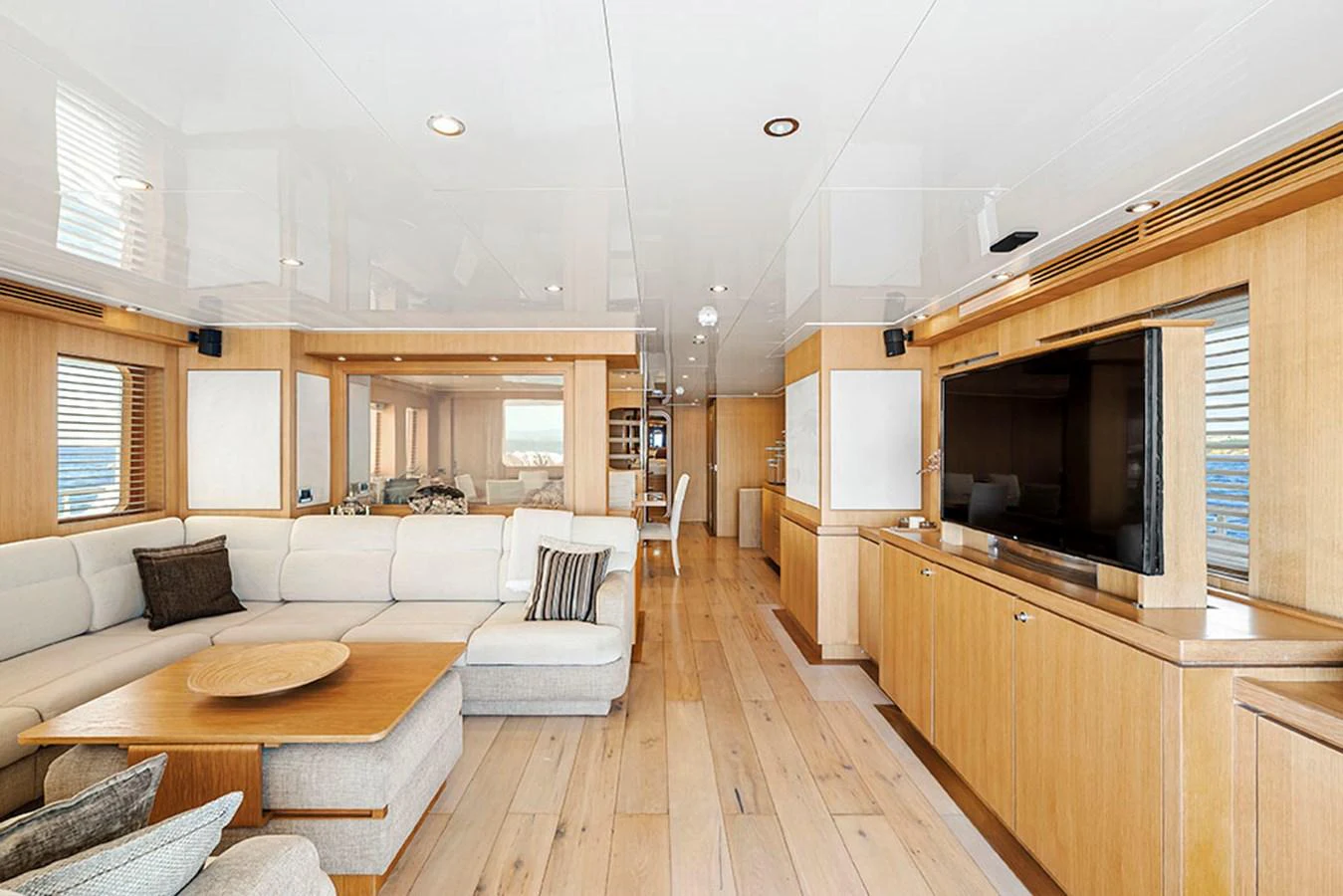 The salon features a spacious seating area with a large television and elegant wooden finishes. aboard BANDIDO Yacht for Sale