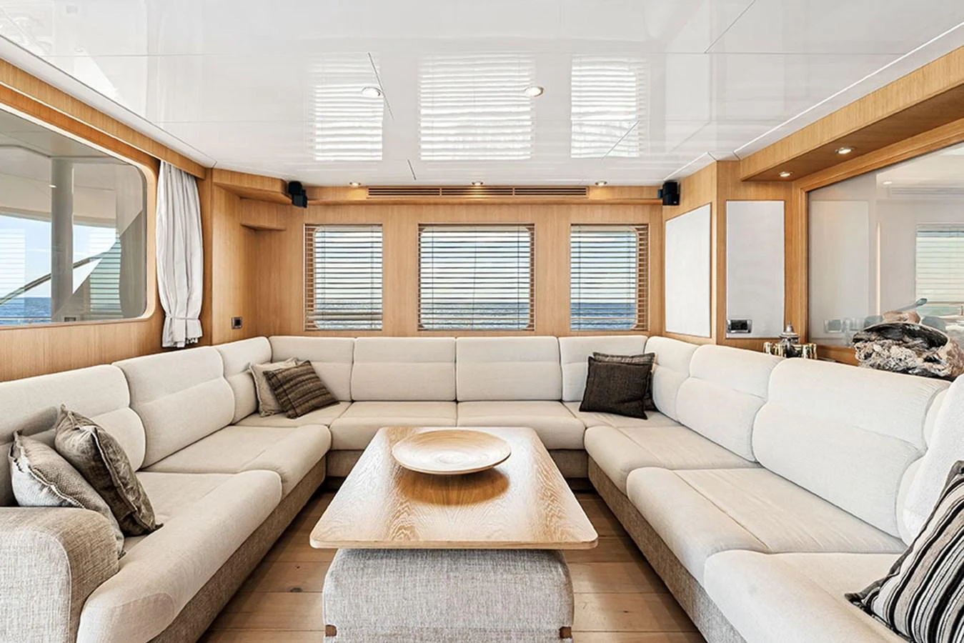The salon features a spacious and inviting seating area with neutral tones and ample natural light. aboard BANDIDO Yacht for Sale