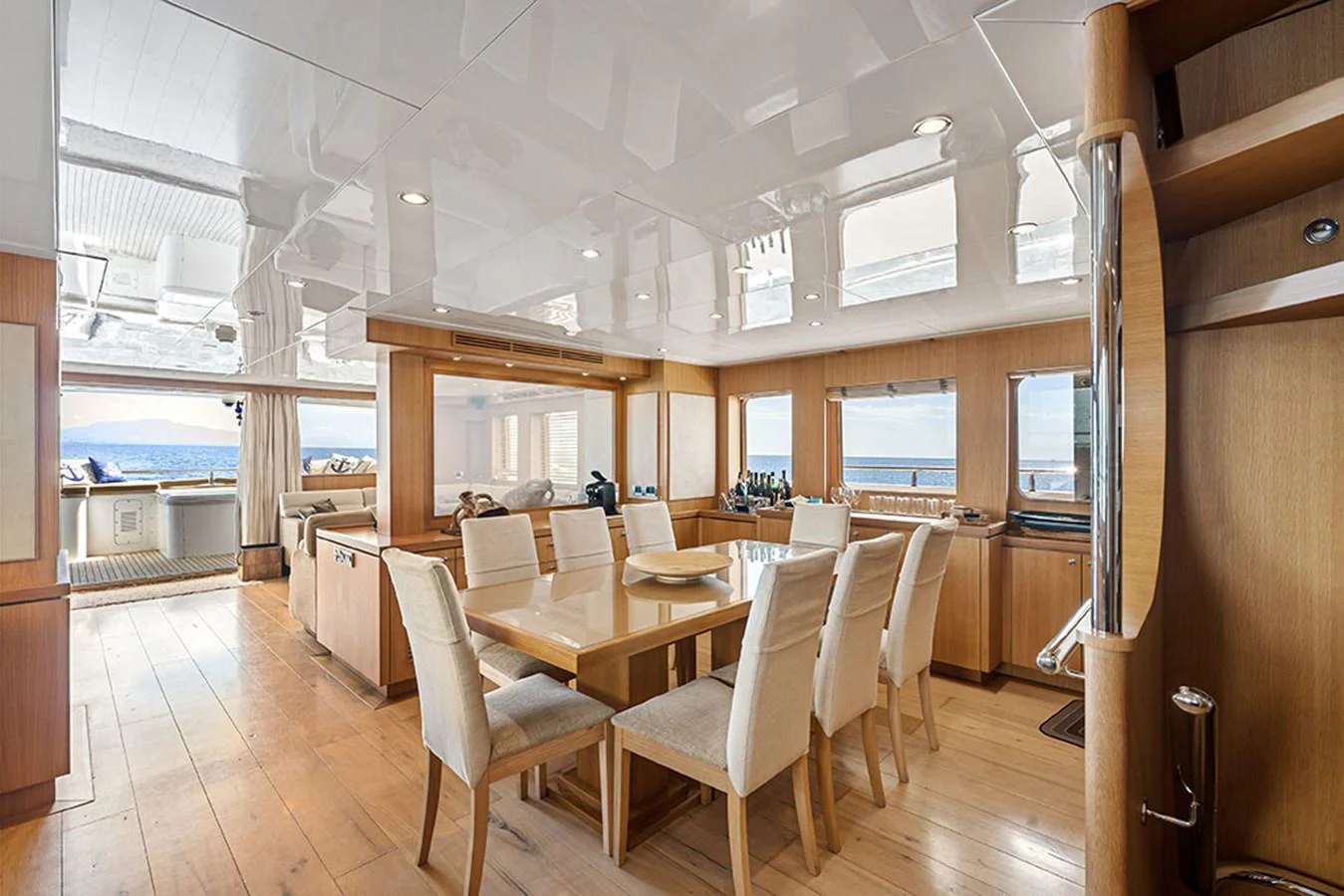 The yacht's dining area features a spacious table with comfortable seating and large windows offering stunning sea views. aboard BANDIDO Yacht for Sale