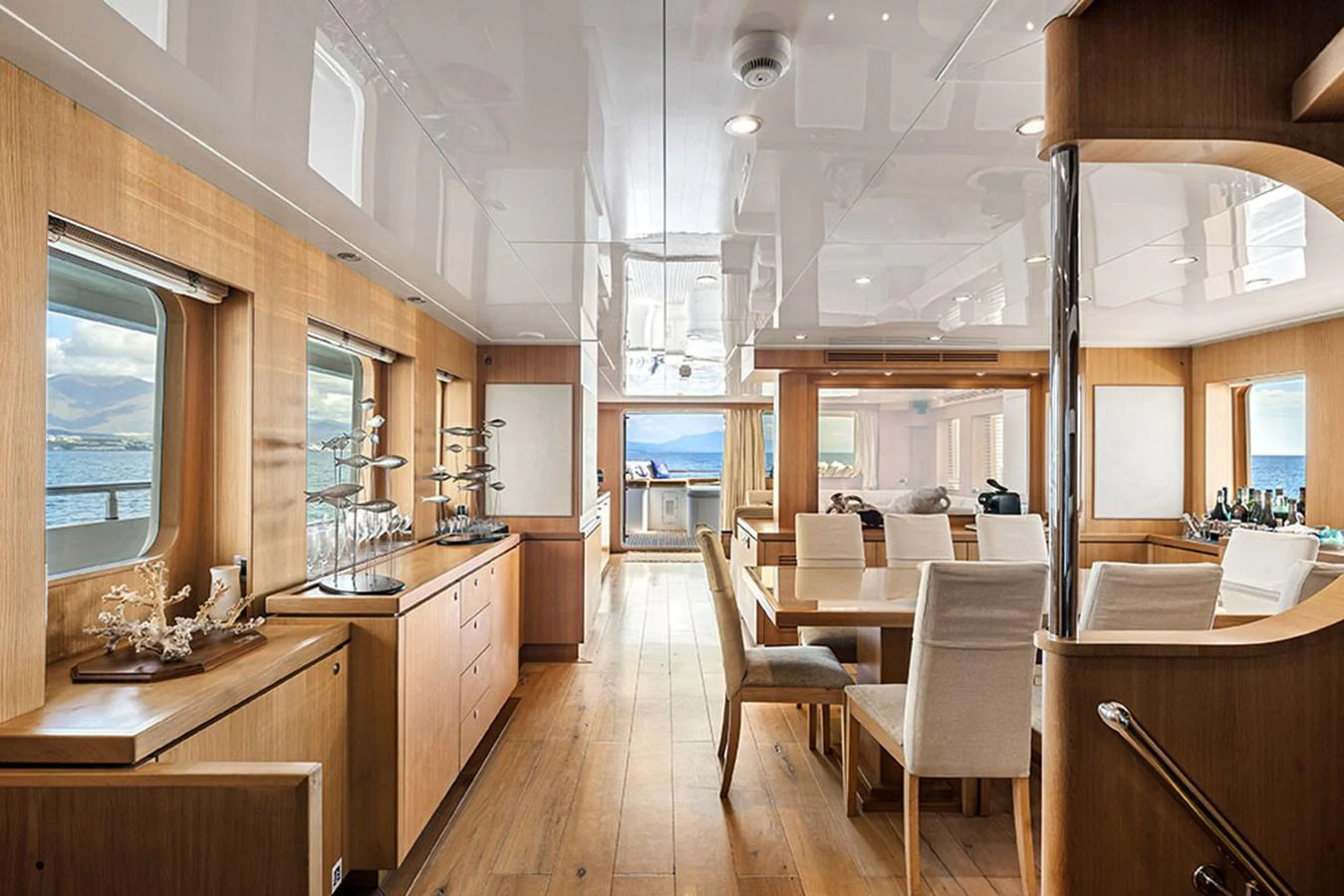 The yacht's dining area features elegant wooden finishes and large windows offering stunning ocean views. aboard BANDIDO Yacht for Sale