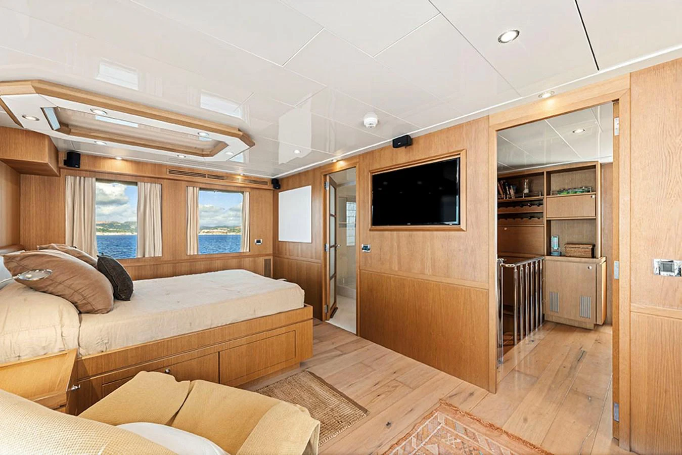 The master stateroom features a spacious bed, ample natural light, and elegant wooden finishes. aboard BANDIDO Yacht for Sale