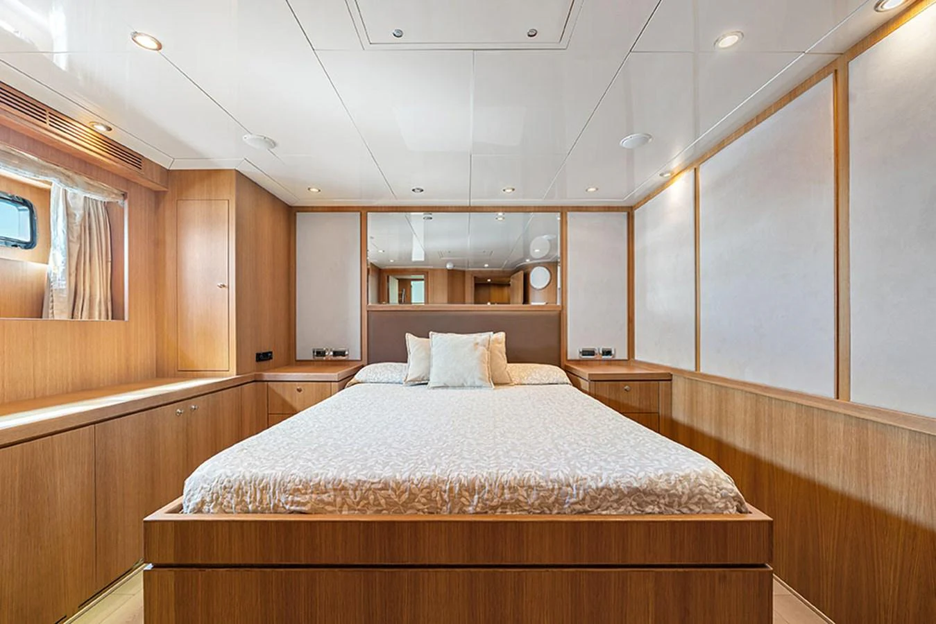 A luxurious stateroom featuring a comfortable bed and elegant wooden finishes. aboard BANDIDO Yacht for Sale