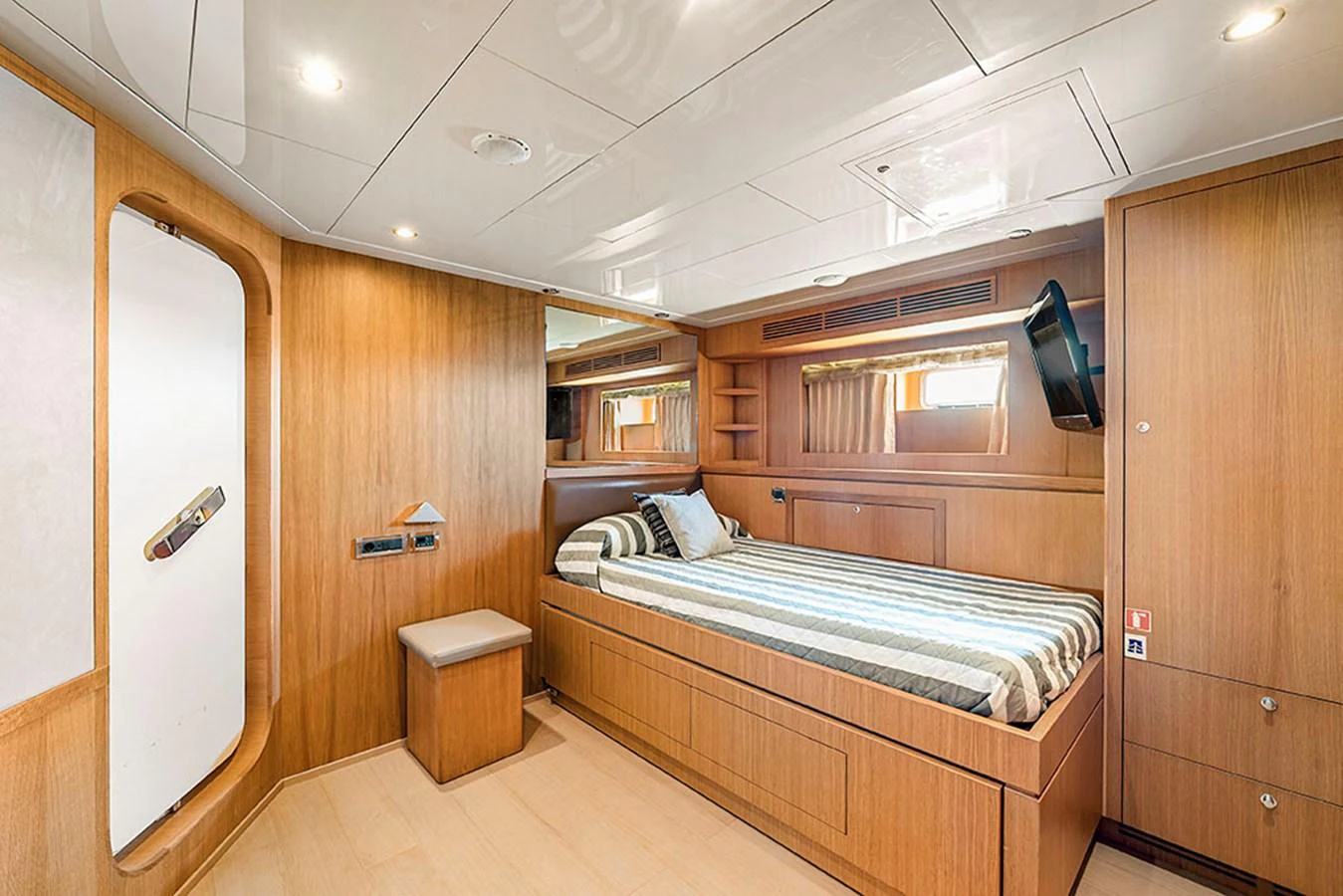 A cozy stateroom with wood paneling and a comfortable bed. aboard BANDIDO Yacht for Sale
