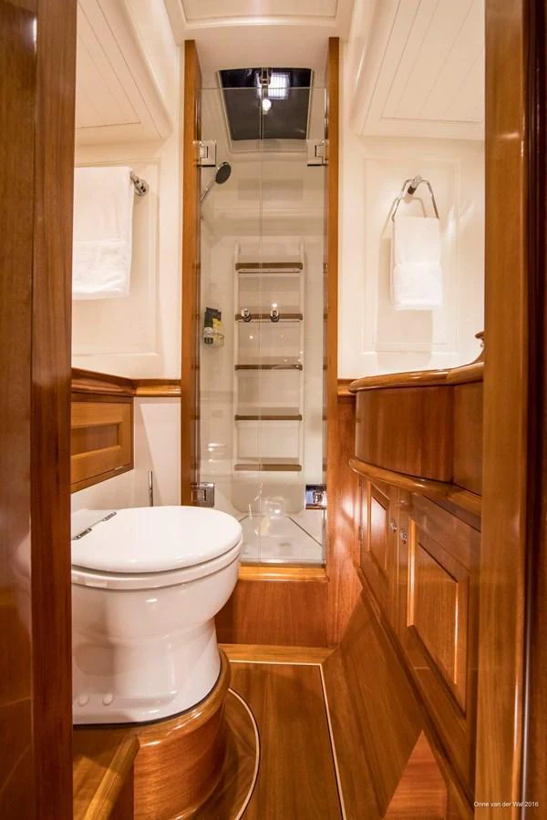 The yacht's bathroom features elegant wooden cabinetry and a modern shower area. aboard ACADIA Yacht for Sale