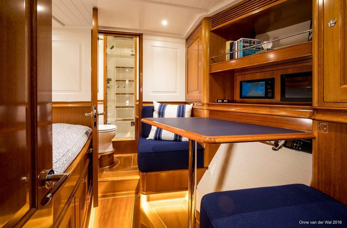 The yacht's interior features a cozy dining area with rich wood finishes and plush seating. aboard ACADIA Yacht for Sale