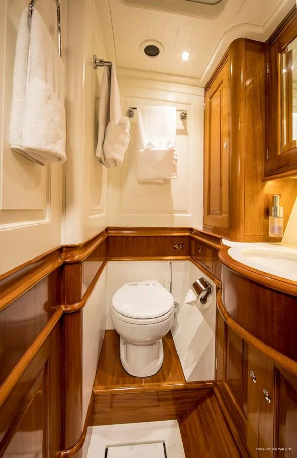 A well-appointed yacht head featuring elegant wood finishes and modern fixtures. aboard ACADIA Yacht for Sale