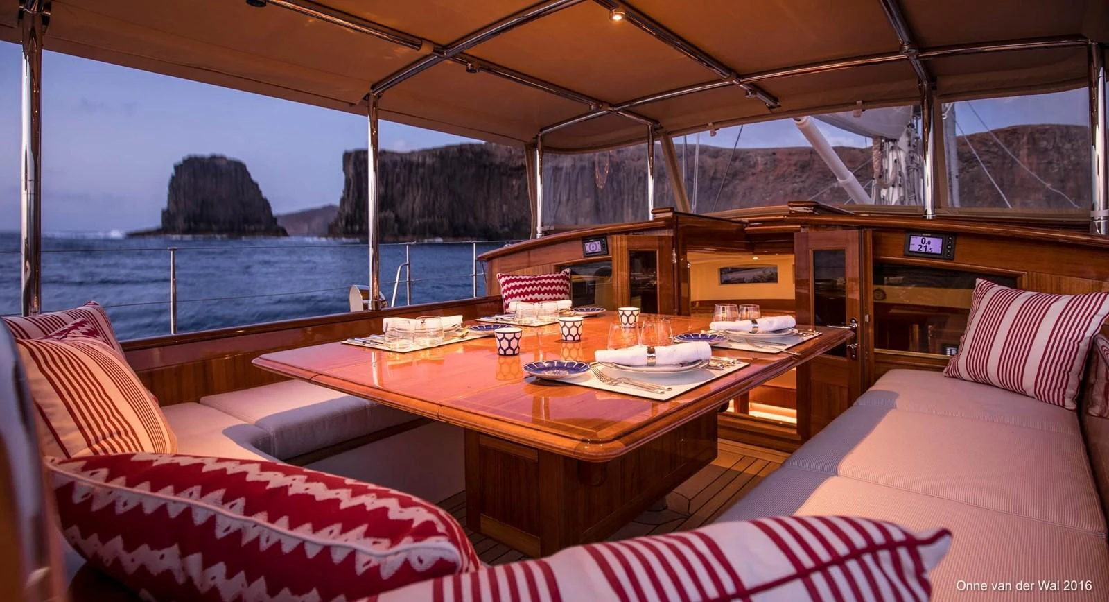The aft deck features an elegant dining area with a stunning view of the sea and cliffs. aboard ACADIA Yacht for Sale