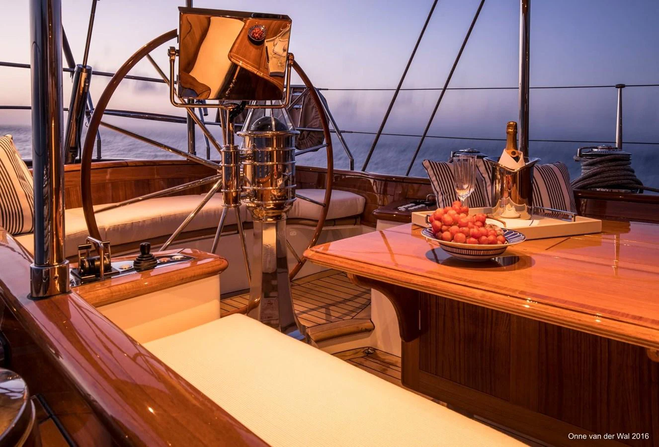 The cockpit features elegant wood finishes and a cozy dining area with a view of the sea. aboard ACADIA Yacht for Sale