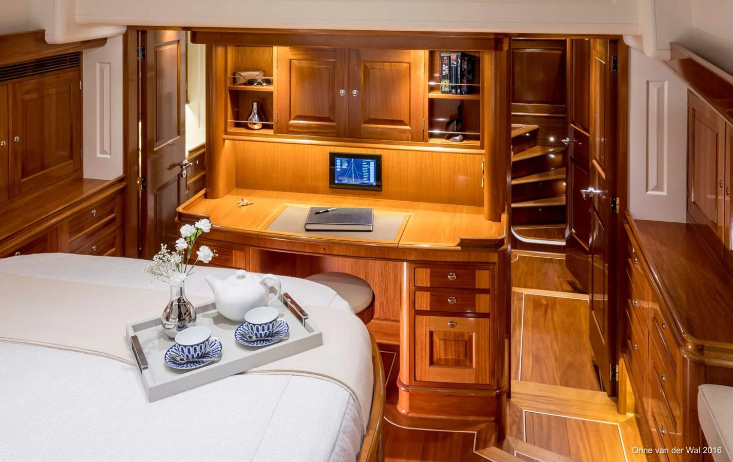 The stateroom features a cozy workspace with elegant wooden cabinetry and a comfortable bed. aboard ACADIA Yacht for Sale