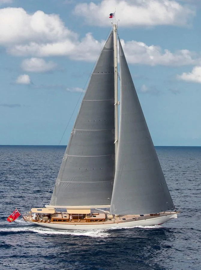 A stunning sailing yacht glides gracefully on the open sea under a clear sky. aboard ACADIA Yacht for Sale