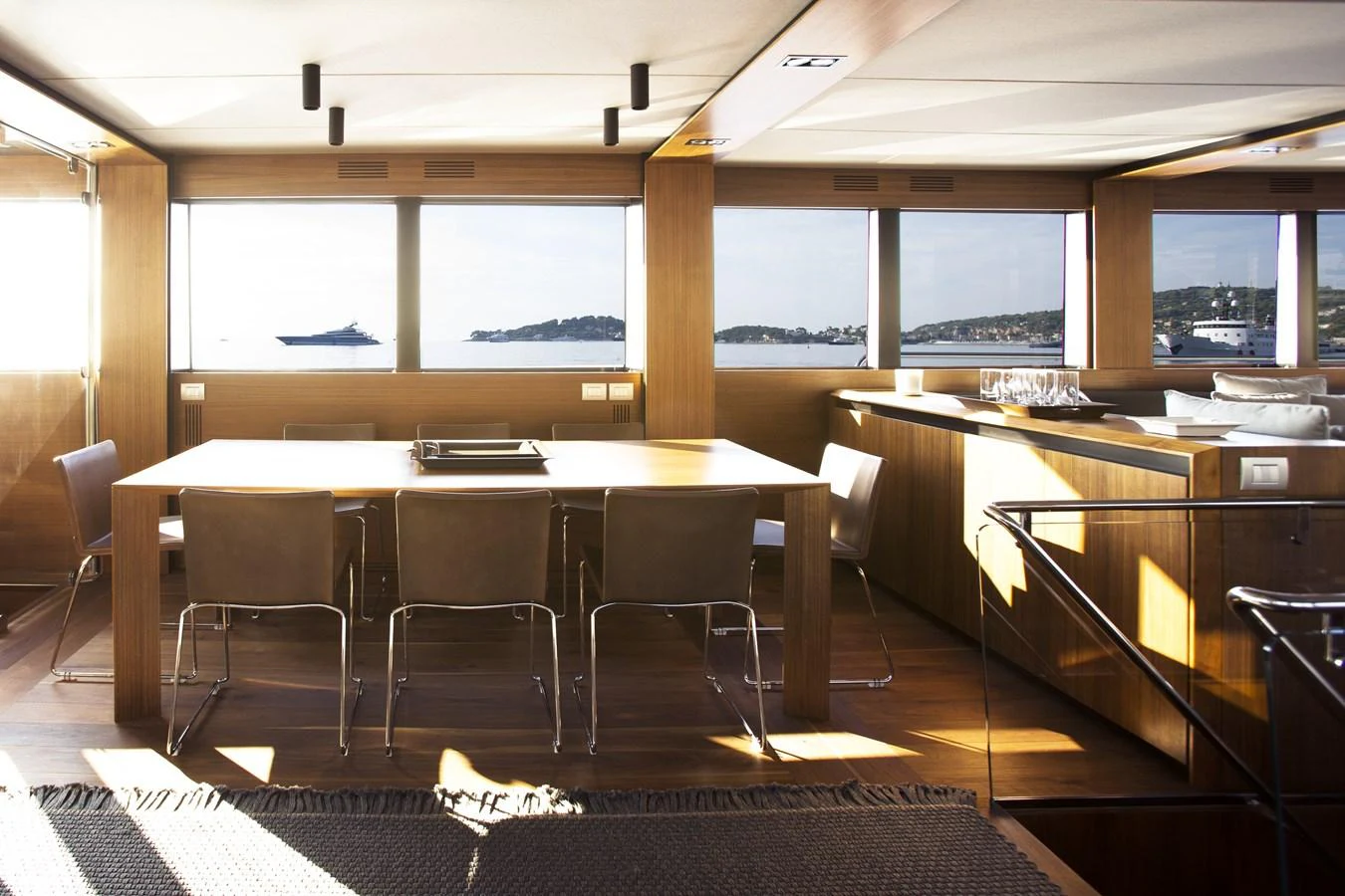The yacht's dining area features a large table with ample seating, surrounded by panoramic windows offering stunning sea views. aboard CASA Yacht for Sale