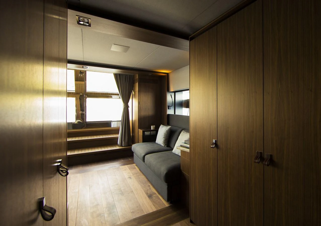 The yacht's interior features a cozy seating area with wooden paneling and ample natural light. aboard CASA Yacht for Sale