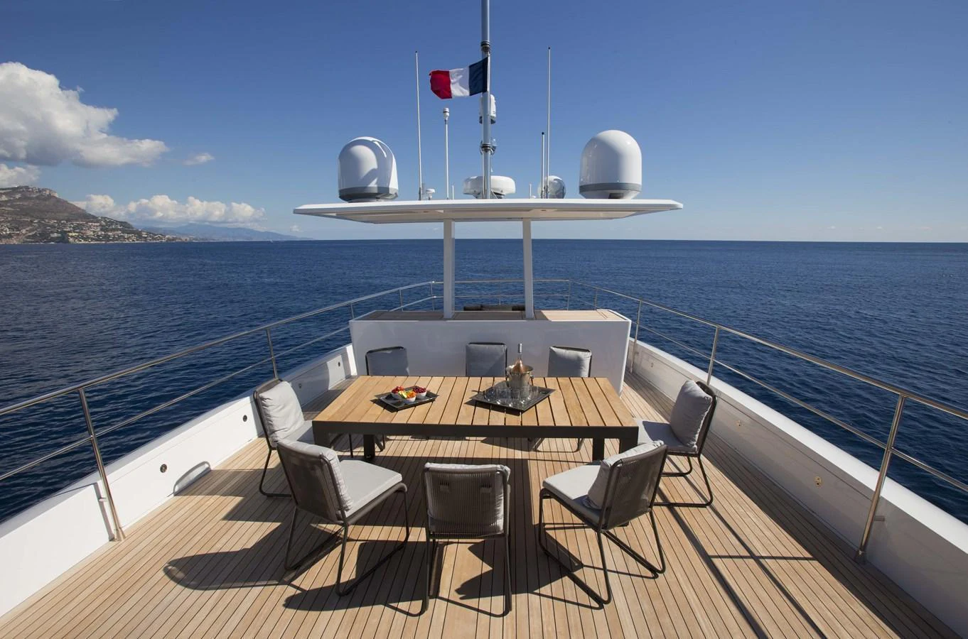 The aft deck features a spacious dining area with a stunning ocean view. aboard CASA Yacht for Sale