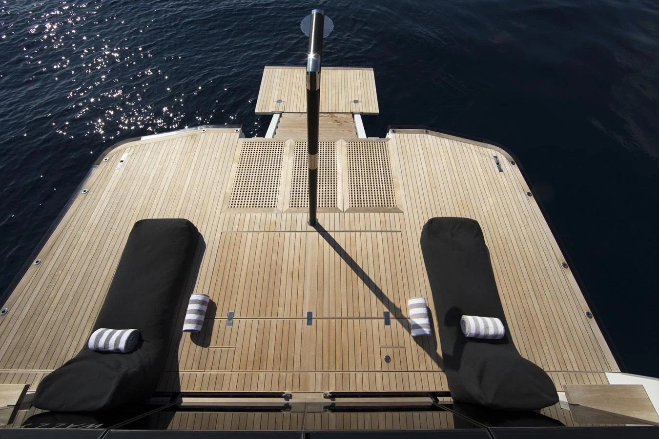 The aft deck features a spacious teak platform with sun loungers, perfect for relaxation by the water. aboard CASA Yacht for Sale