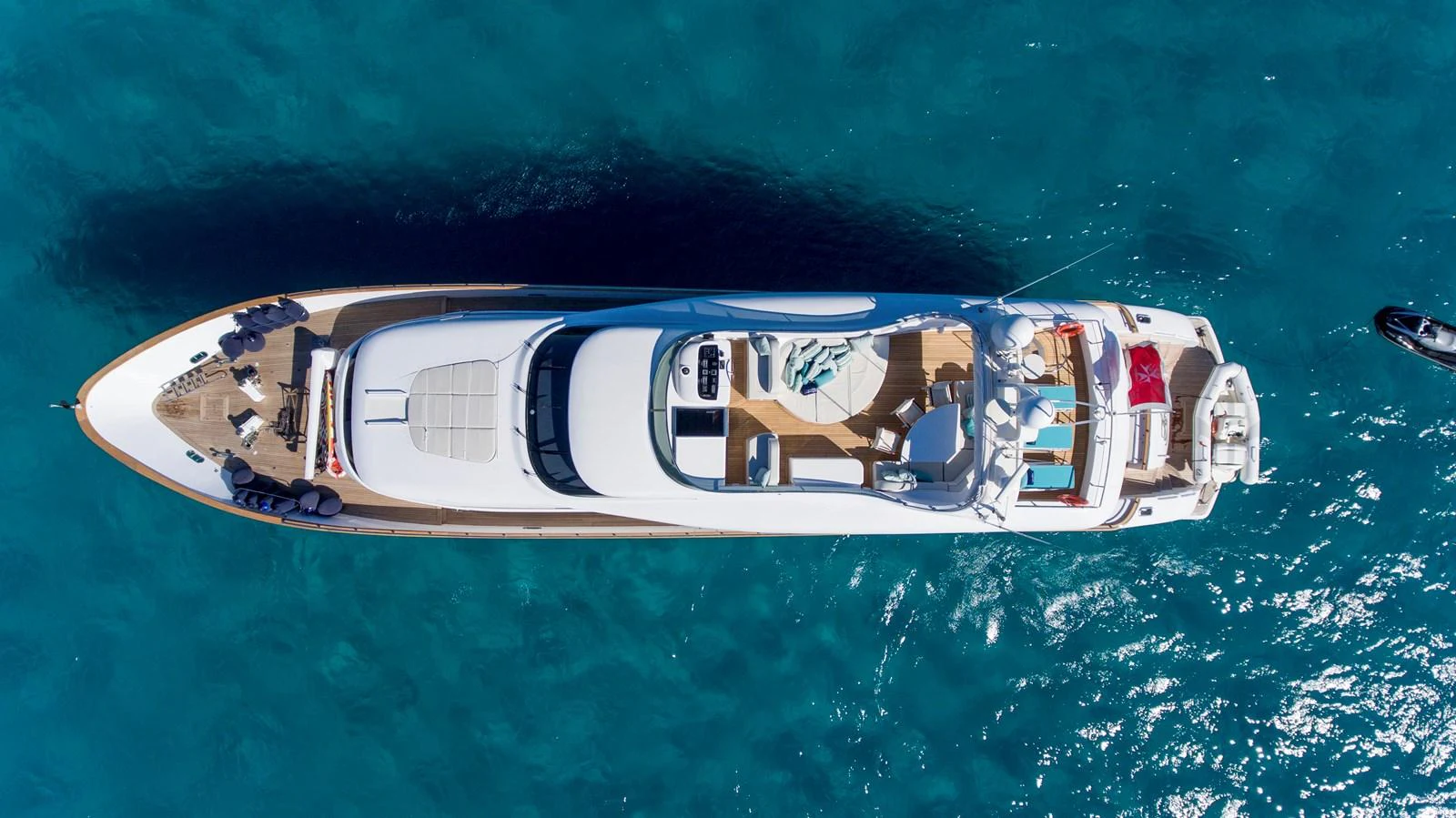 Aerial view of a luxurious yacht cruising on clear blue waters. aboard AMAYA Yacht for Sale